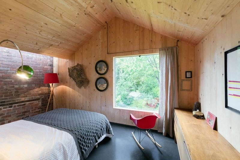Schlafzimmer im Anbau mit Holzverkleidung und Gartenfenster